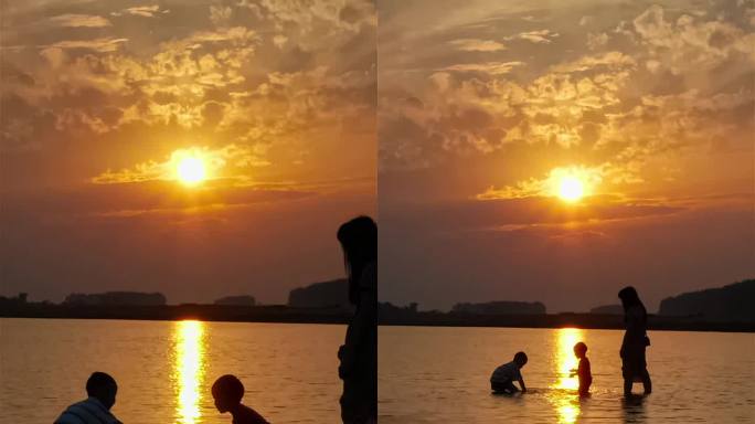 小河夕阳下两个小宝贝在妈妈面前玩水嬉戏竖