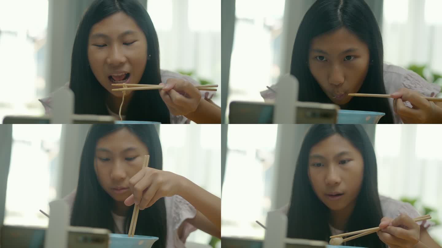 亚洲女孩在家里的餐厅里吃面汤，用智能手机看电影或病毒式视频，这是周末生活方式的概念。