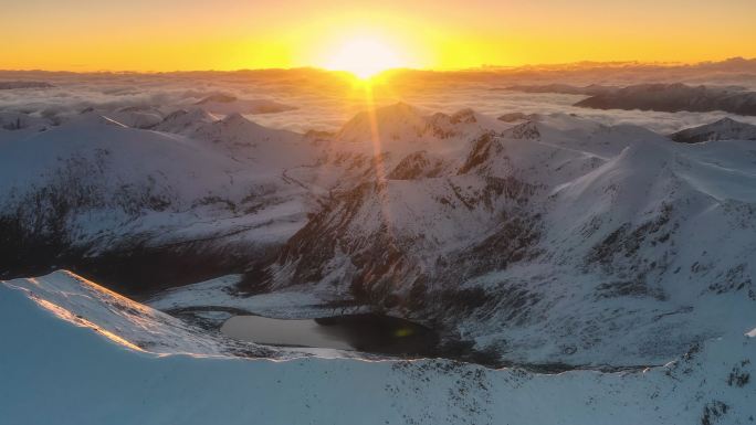 当太阳升起时，一个黑色的湖泊静静地躺在雪山的怀抱里