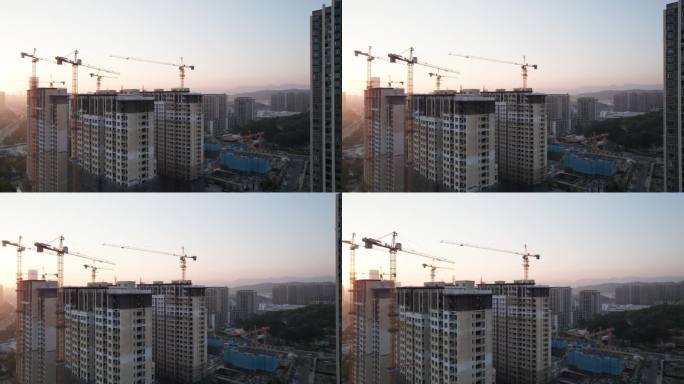 日落时建筑施工现场起重机的高角度视图