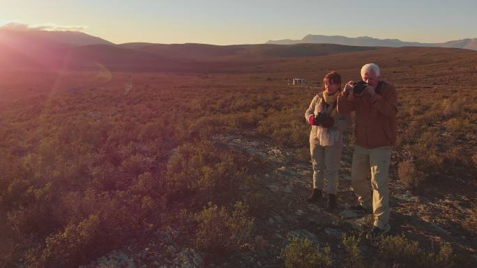 一对老年夫妇在阳光明媚的偏远地区与旅行团一起进行狩猎旅行