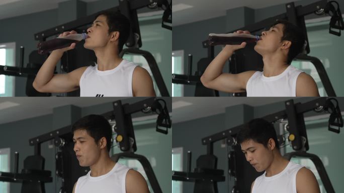 亚洲男子在健身房锻炼后喝可口可乐