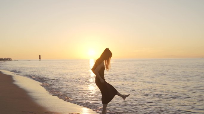 阳光下美女跑向海边玩耍踢海水欢快女孩少女