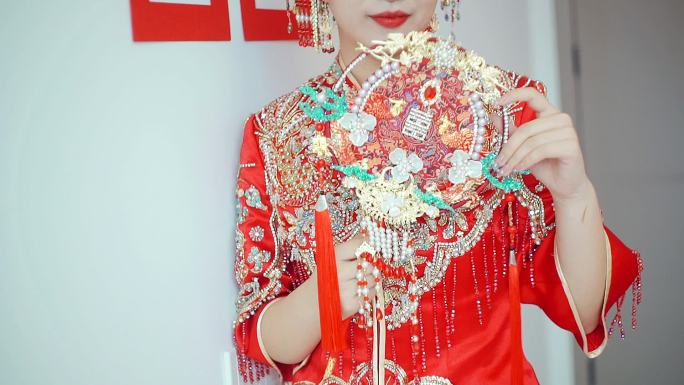 中式秀禾服的新娘拿着中式扇子