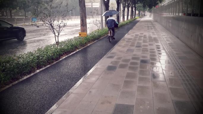 下雨天路上骑自行车的行人和车辆