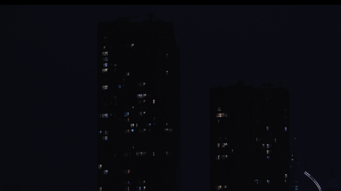 夜晚两栋高楼的灯光闪烁 辛苦工作的人们