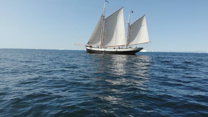 帆船沿着阳光明媚的蓝海格陵兰岛航行
