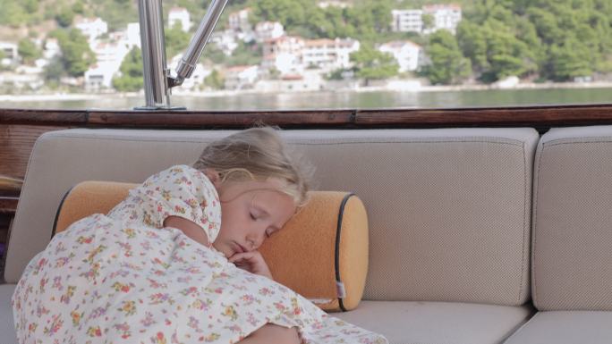 小女孩在游艇上乘船旅行时休息。