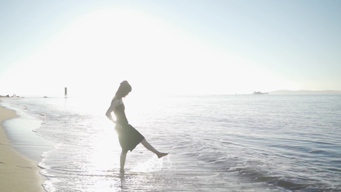 阳光下美女跑向海边玩耍踢海水欢快女孩少女