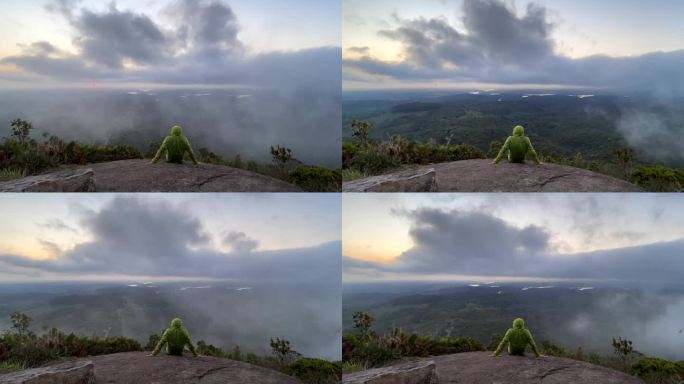 一个人坐在山顶上观看日落的时间流逝。