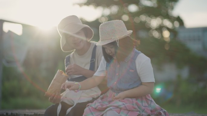 可爱的女孩和妈妈一起喂鸭子