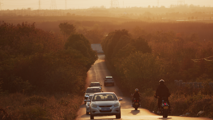 金色夕阳下的乡村道路车流