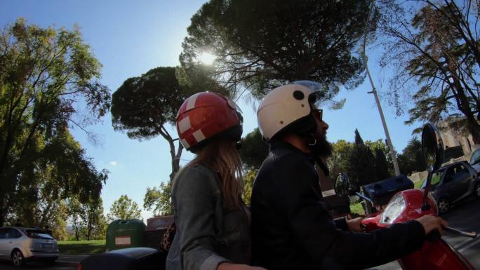 自拍滑板车骑行：在罗马竞技场骑摩托车的游客夫妇