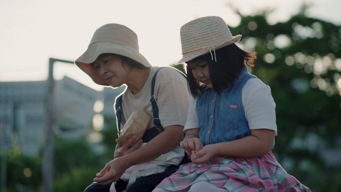 可爱的女孩和妈妈一起喂鸭子