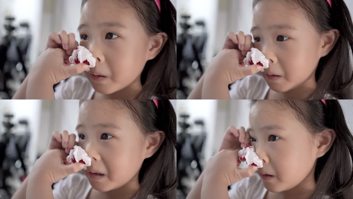 一个小女孩用纸巾擦出血的鼻子的特写镜头