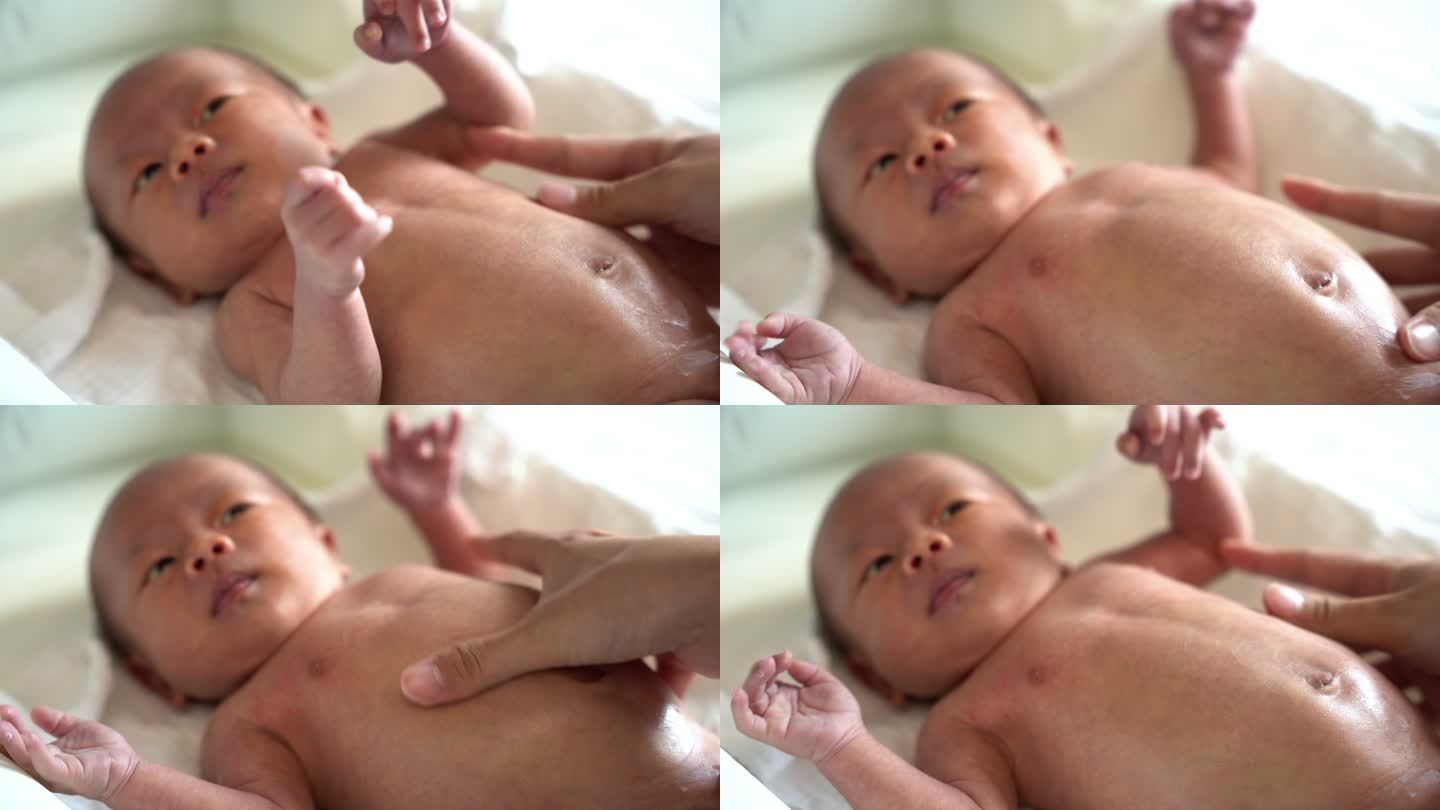 母亲在新生儿身上涂抹婴儿霜