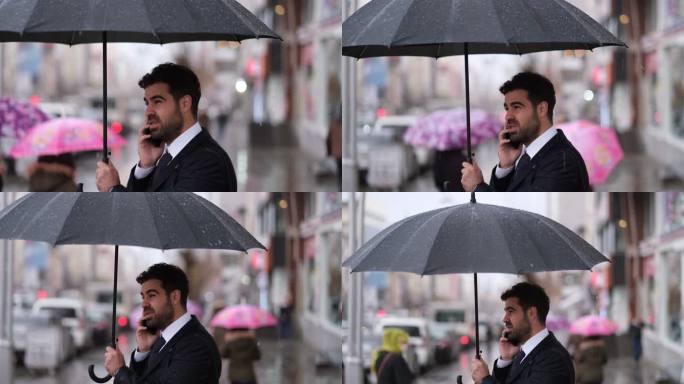 雨中的快乐商人商务人士雨中打伞打电话