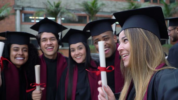 大学毕业典礼结束后，一群快乐的朋友与某人视频通话