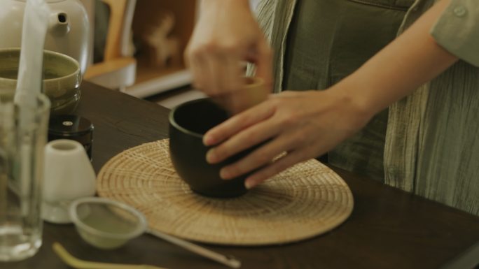 亚洲女性手工制作传统的禅抹茶。