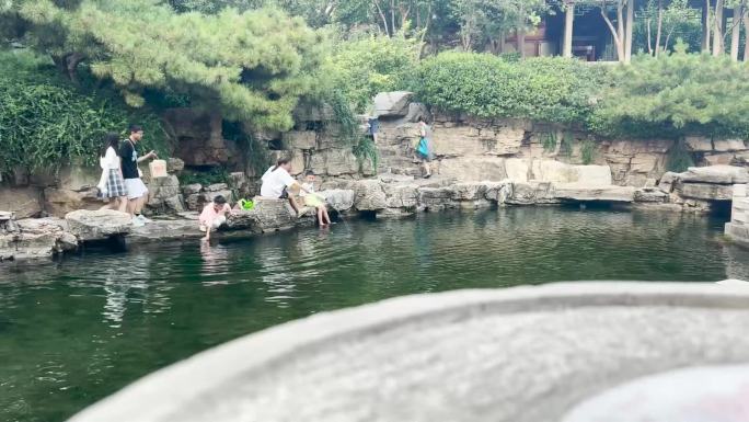 水边游客玩水呲水枪清澈水面
