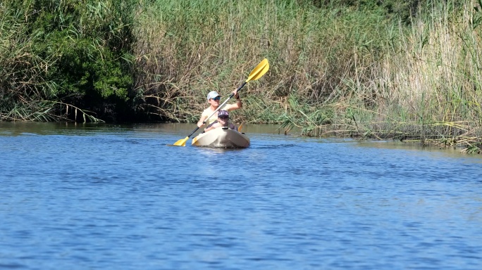母亲和女儿在河中划皮划艇