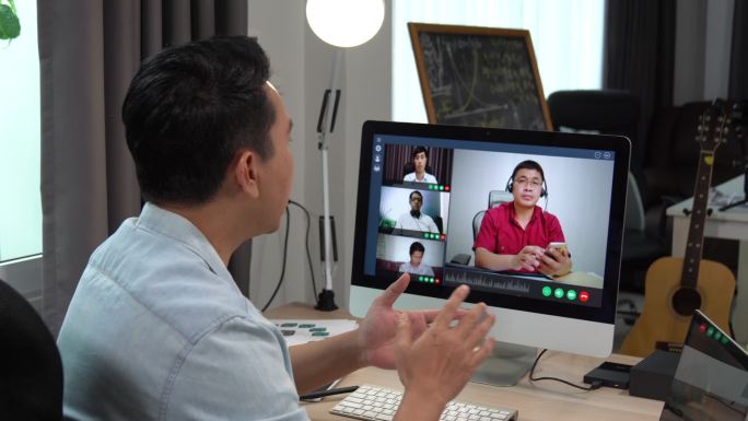 商务人员通过电脑与团队进行视频会议通话。