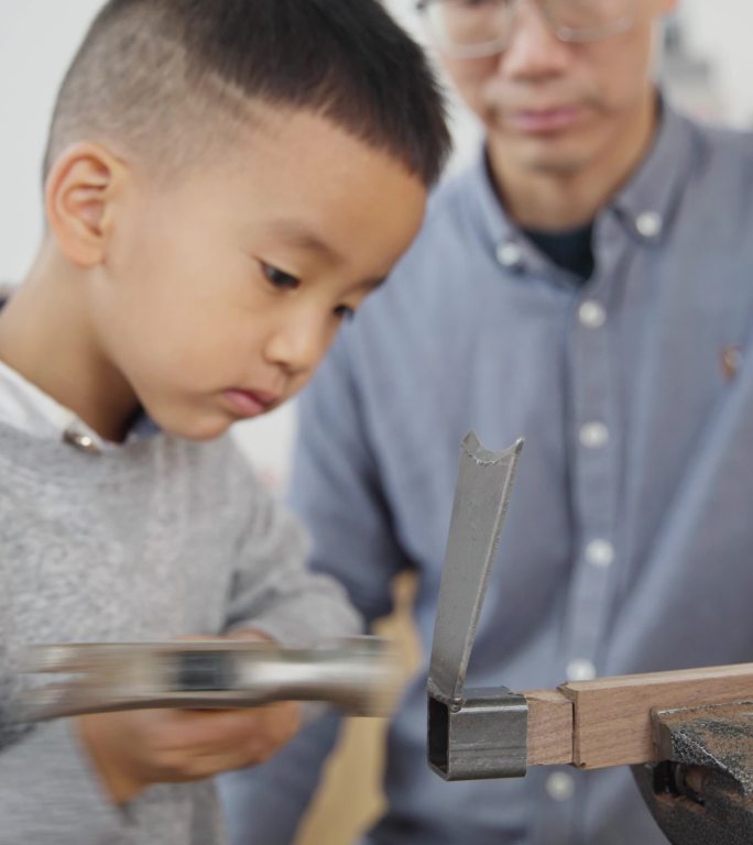 小朋友熟练使用木工工具工匠制作打磨小锄头