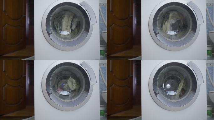 洗衣机旋转滚筒并洗涤衣物。