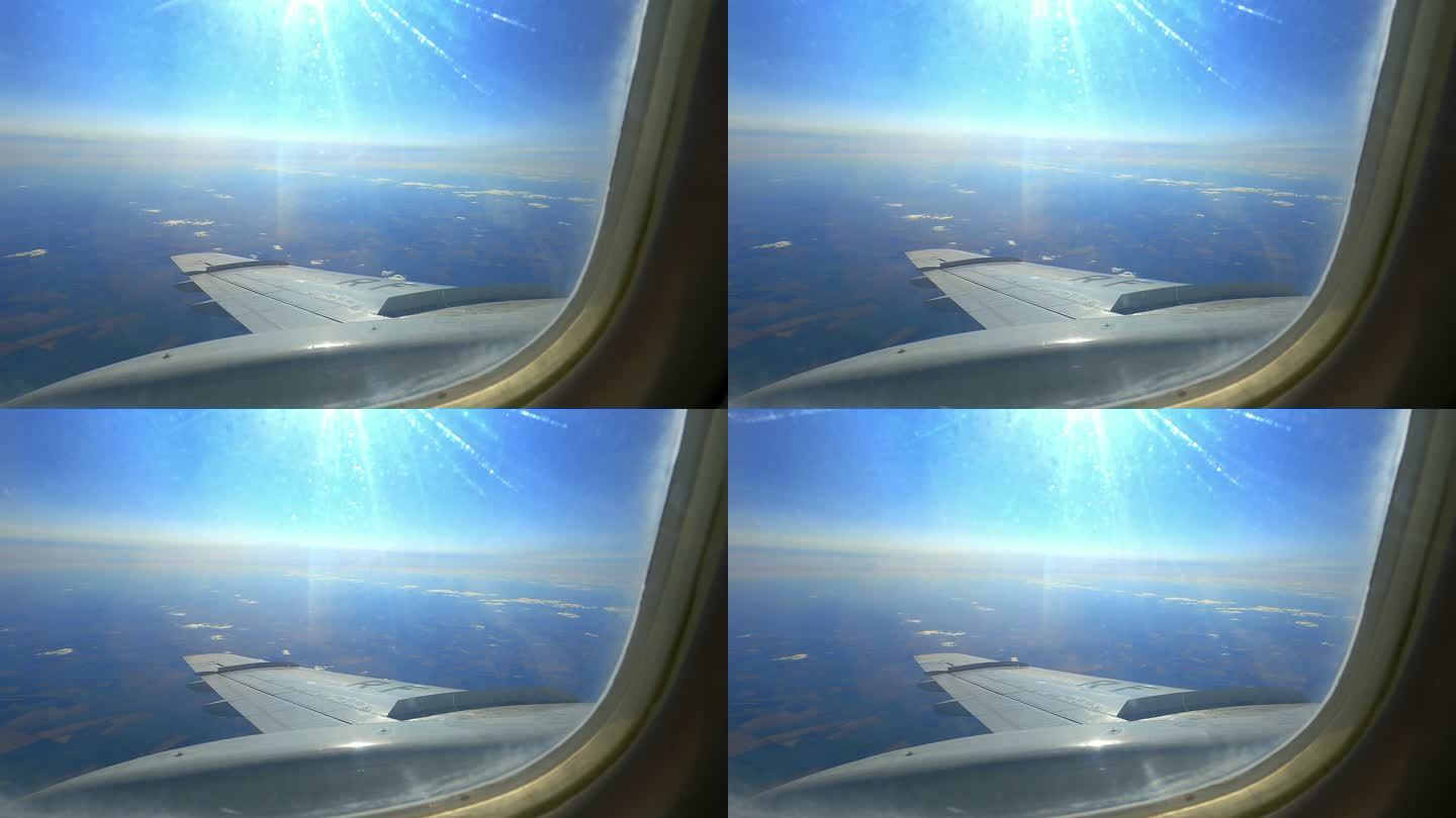 阳光照射在飞机窗口的机翼上