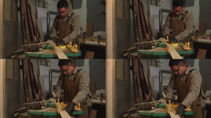亚洲木匠正在商店里使用木屑切割工具。