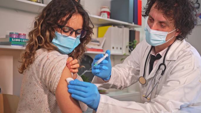 医生为女性患者注射疫苗