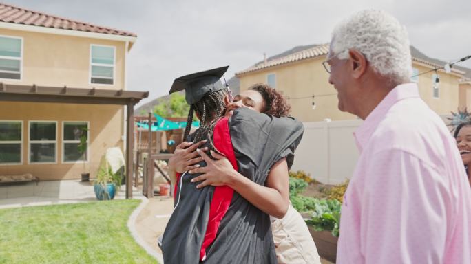 年轻的黑人女子在毕业派对上拥抱家人
