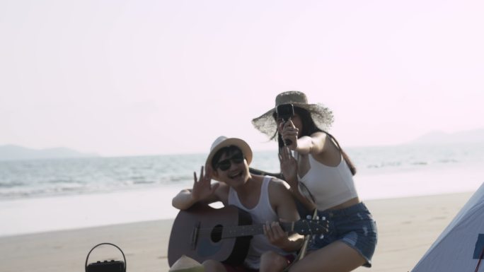 亚洲朋友在海滩露营度假。