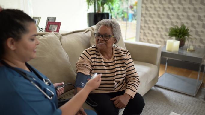 护士在家为一名老年患者测量血压