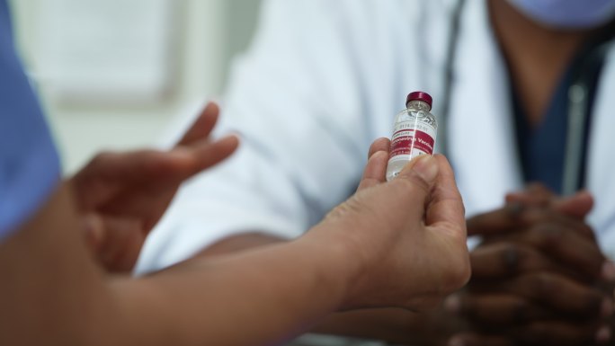 医疗专业人员携带一瓶新冠肺炎疫苗