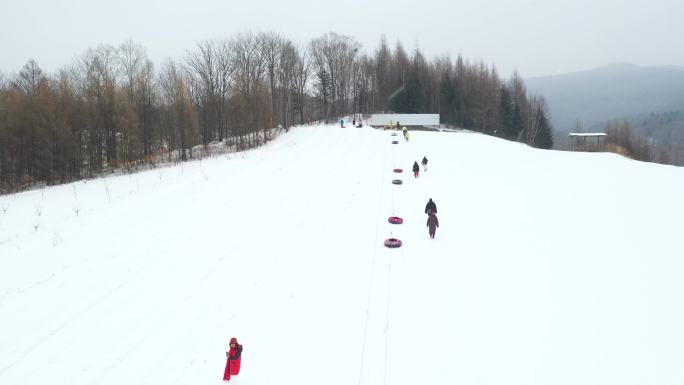 4k航拍滑雪场划雪圈玩雪圈的人们