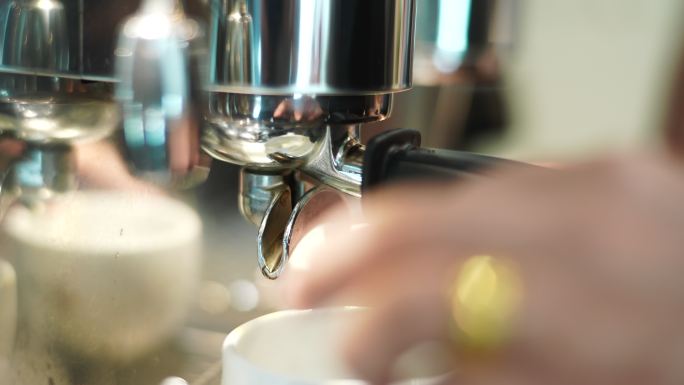 选择性聚焦咖啡从浓缩咖啡机滴入杯子