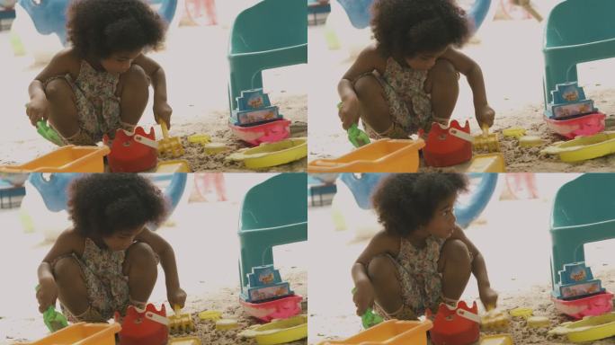 玩沙子的非洲女孩。