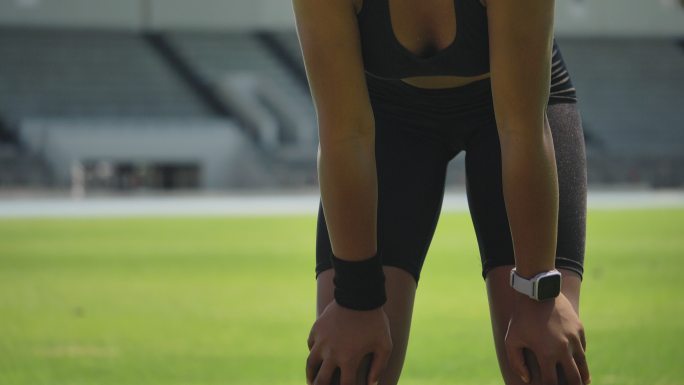 女田径运动员戴着面罩和智能手表休息