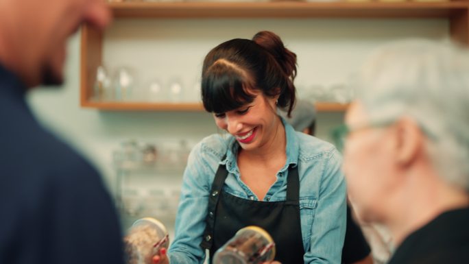 微笑的女咖啡店员工咖啡师在咖啡馆工作