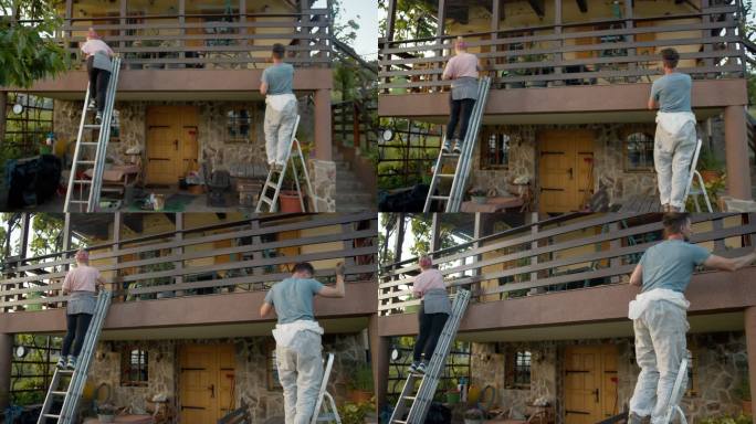 SLO MO夫妇用梯子油漆阳台上的木栅栏