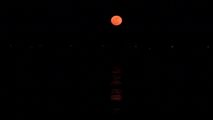 夜晚城市上空红月亮实拍