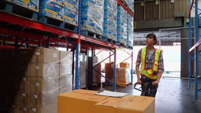 女工将装有纸板箱的送货卡车装载到零售商仓库的存储空间。基于电子商务和交付概念的在线订单购买