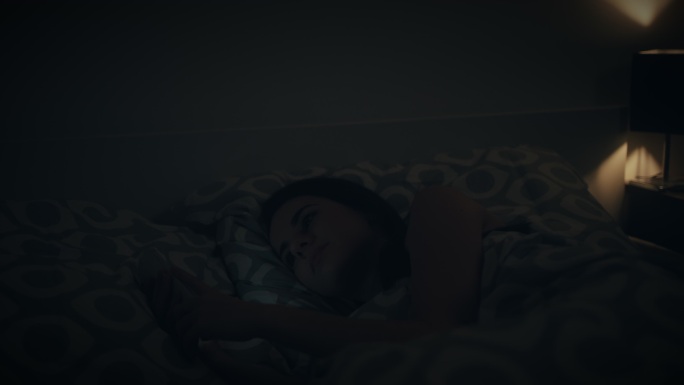 女子深夜在家中打瞌睡时使用手机