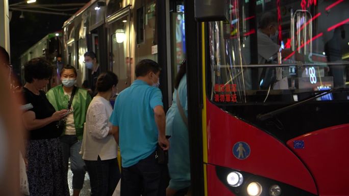 乘客晚上排队上公交车