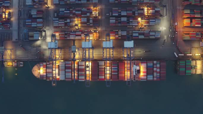 集装箱船夜间作业，商业进出口物流和国际集装箱船在公海的运输，鸟瞰图。