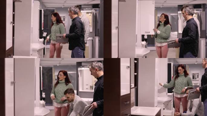 在短暂的参观之后，在商店浴室陈列室，年轻夫妇向推销员展示了他们想买的药柜
