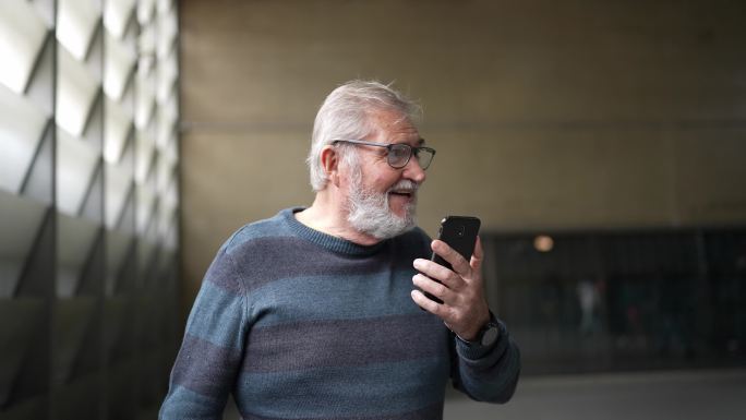 一名在地铁站用手机视频通话的老人