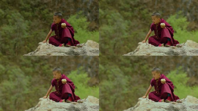 小喇嘛坐在石头上啃馒头