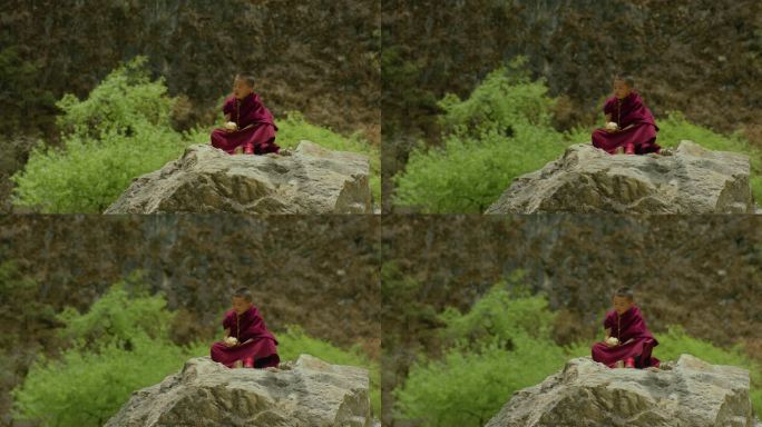 小喇嘛坐在石头上啃馒头